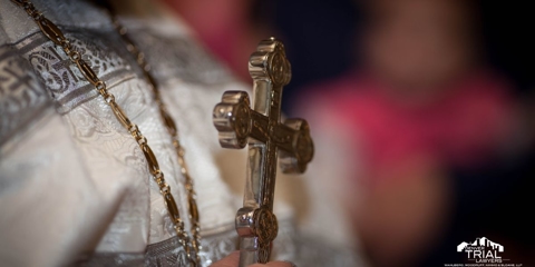 Clergy Member holding a large crucifix.